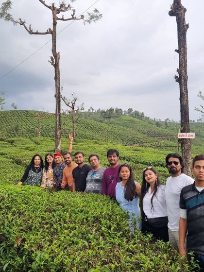 A group photo amidst the endless green of a Valparai tea estate. The sheer scale of these plantations is something you have to see to believe.
