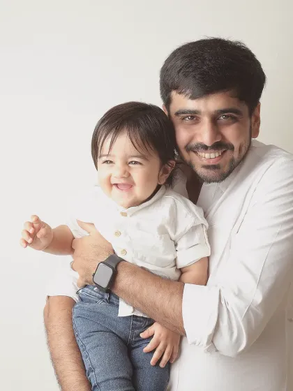 The bond between a father and his child is a special kind of happiness. This candid studio portrait is all about that infectious laughter and the simple joy of being together.
