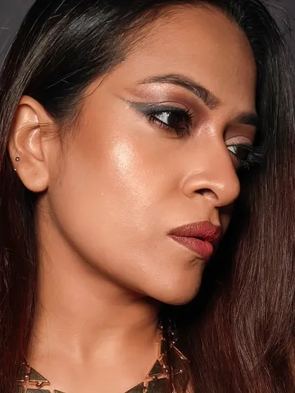 This side profile highlights the sharp wing and the glowing skin from the glam look. Notice how the highlighter on the cheekbone complements the eye makeup without competing with it.