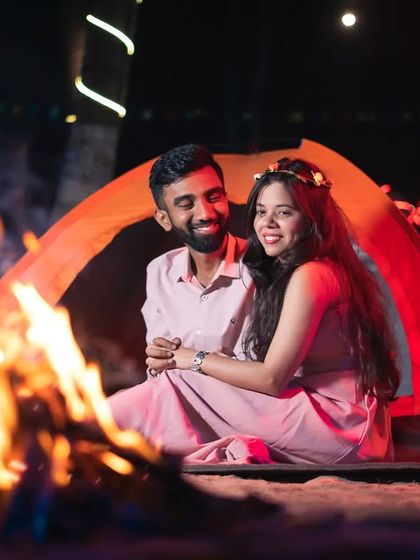 A happy and relaxed portrait by the campfire. This shot captures the joy and coziness of a romantic night spent together under the stars.