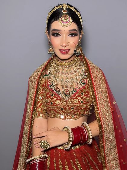 A smiling bride looking directly at the camera. Her makeup is fresh and bright, and she looks ready for her big day.
