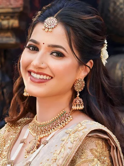 A radiant smile is the best accessory. This South Indian bride's look is all about enhancing her natural beauty with glowing skin, a warm smile, and beautiful temple jewelry.