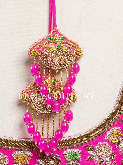 This bright pink raw silk blouse is a showcase of exquisite craftsmanship. The sleeves and back are covered in dense, multi-colored floral handwork, and I added beautiful custom tassels with bead detailing to complete the look.