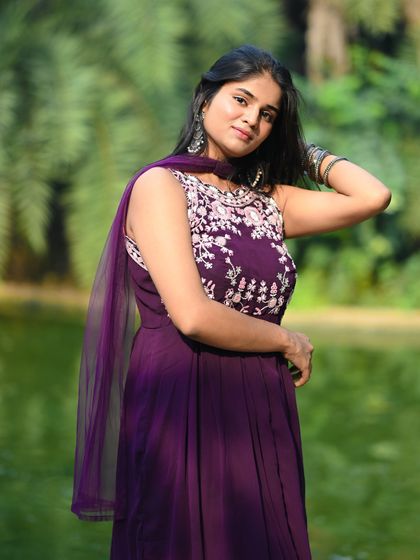 A half-body shot of the model in her purple ethnic dress, looking elegant against the green backdrop of the park.