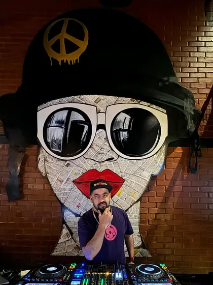 Posing in front of a massive, cool art piece behind the DJ booth.