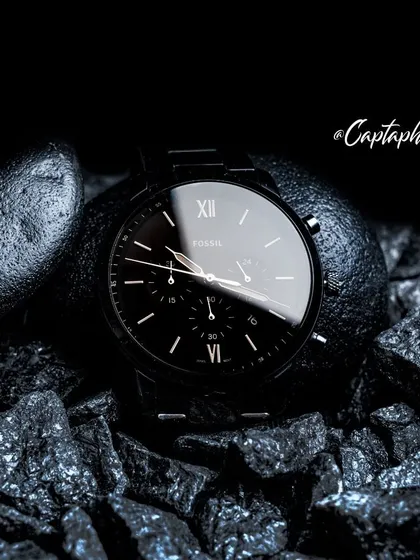 A wider composition from the Fossil watch concept shoot, showing the full watch in its environment. This shot establishes the overall mood and provides context, showcasing how the product interacts with the textured elements. It's a powerful image for lifestyle branding and advertising.