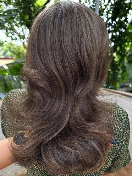 Getting her holiday-ready with a cool ash brown. This color is perfect for neutralizing unwanted warm tones and creating a sleek, modern look.