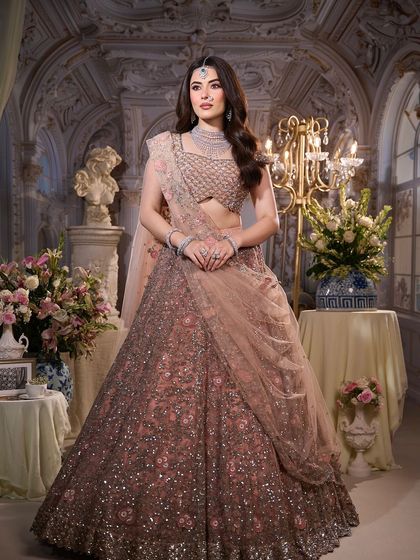 A full-length view of this dreamy, modern bridal look. The makeup is kept soft and elegant to complement the heavily embellished lehenga.