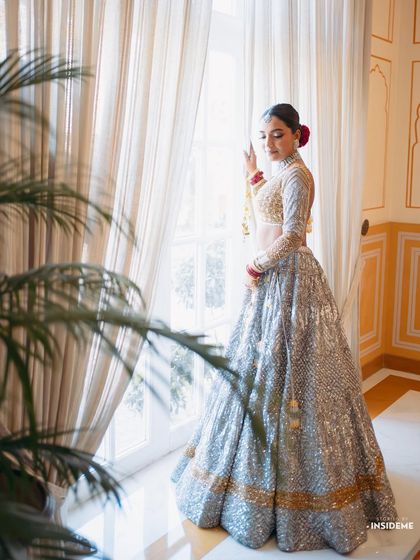 A full-length view of Mishi's stunning and contemporary bridal lehenga, complemented by a sleek bun and fresh makeup.