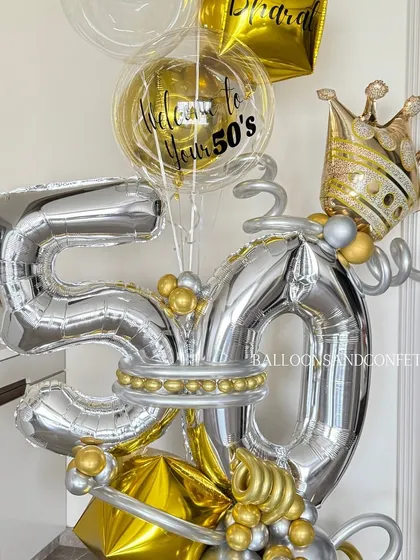 Celebrating a half-century in style! This grand 50th birthday balloon bouquet in silver and gold, complete with a crown, is designed to be a magnificent centerpiece for a milestone celebration.