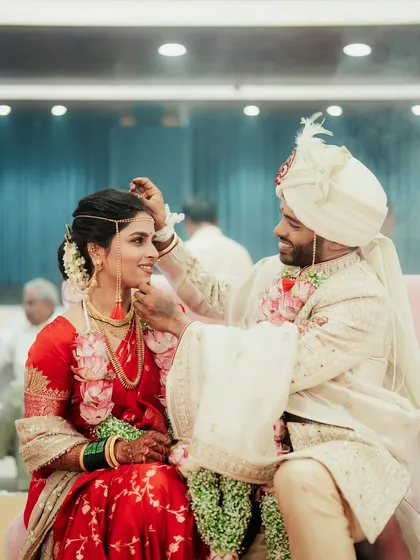 A beautiful moment during the wedding ceremony where the groom is applying sindoor to the bride.