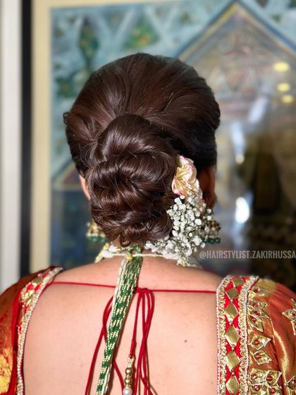 A classic bridal bun decorated with a gajra of fresh flowers. This timeless style is perfect for a traditional wedding ceremony.