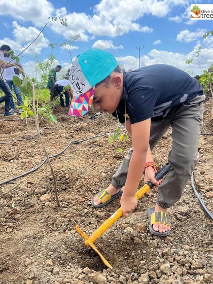 A young boy diligently digs a pit for a new sapling during the EXL drive in Pune. It's wonderful to see the next generation so engaged.