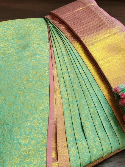 A sea-green client saree, perfectly folded and ready to be delivered.