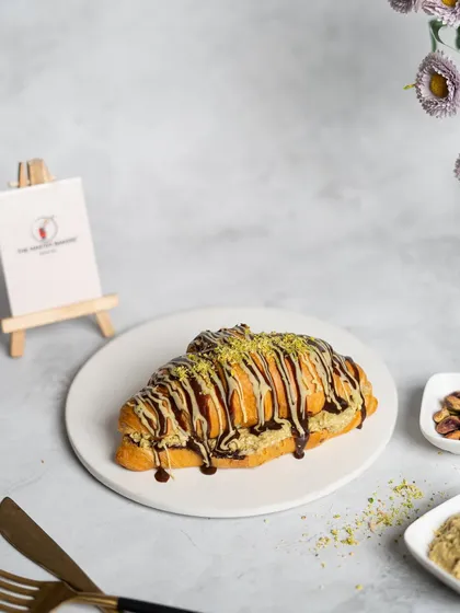 Meet our famous Croissant Prashant. We took a flaky, buttery croissant, stuffed it with sweet and crispy kunafa, and drizzled it with chocolate. It's the unique flavor and texture combination that started a craze.