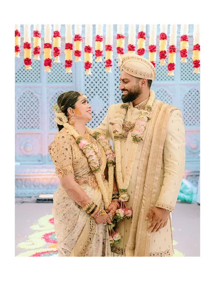 An intimate moment between the bride and groom. This photo offers a great view of the side profile of the groom's sherwani and the way the embroidered shawl is draped over his shoulder.