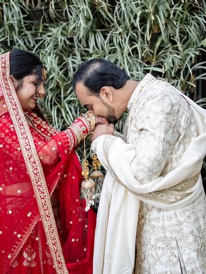 A chivalrous groom kisses his bride's hand during their 'first look' session. A classic, romantic gesture.