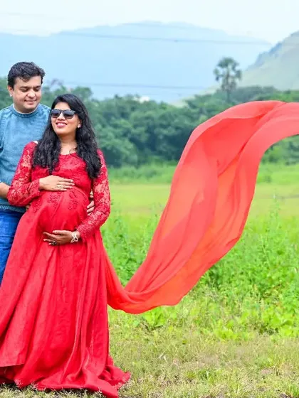 A beautiful outdoor shot with a wide-open field and mountains in the distance. The red flowing fabric adds a pop of color to the natural landscape.