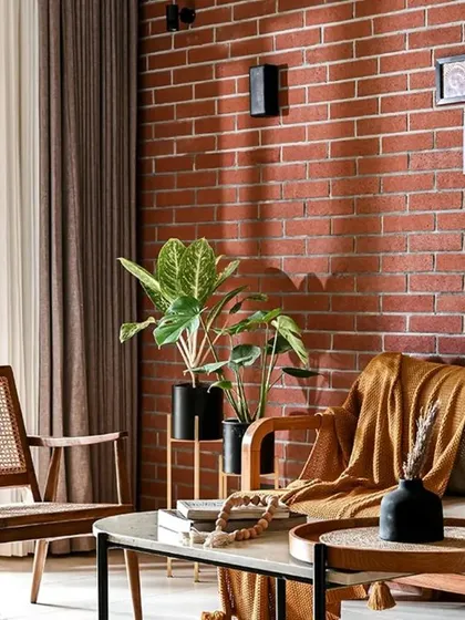 This shot captures the warm and inviting atmosphere of the living room. The combination of the brick wall, wooden furniture with cane details, and soft lighting creates a space that feels both rustic and modern.