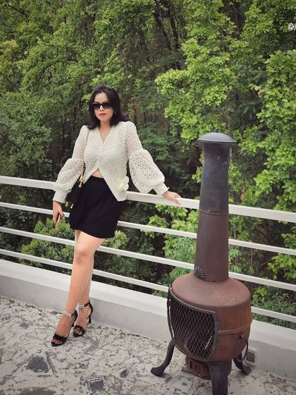A birthday look featuring a white lace top and black shorts, seen here on a beautiful balcony.