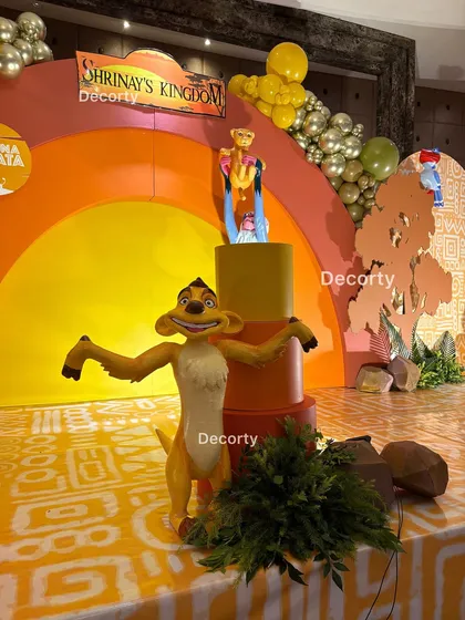 A close-up view of the stage decor, focusing on the Timon cutout and the layered backdrop.