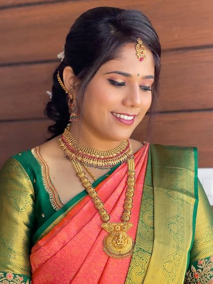 A smiling shot of Gagana, showcasing her fresh and radiant makeup for her welcome ceremony. The look is designed to be bright and photograph well.