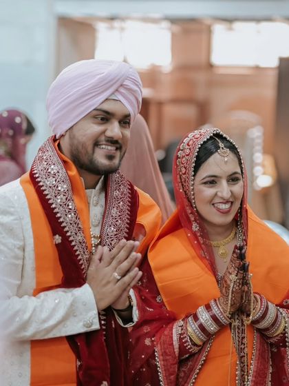The couple expresses their gratitude with folded hands, their faces beaming with happiness after the ceremony.