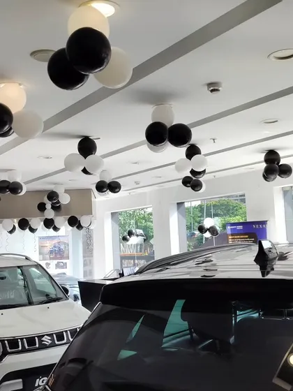 We use balloon clusters on the ceiling to add a festive touch throughout the entire showroom space. This approach ensures the celebratory atmosphere is felt in every corner of the NEXA dealership during their launch event.