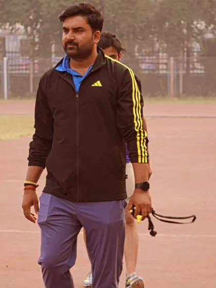 Focused on the track, observing my athletes during a training session.