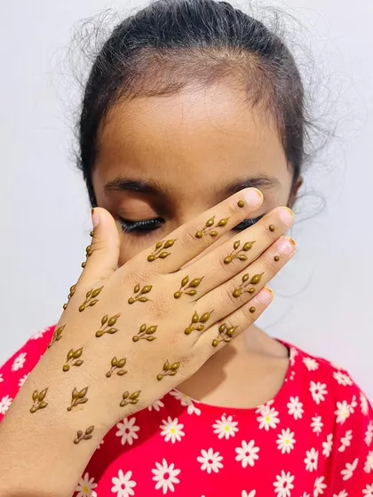 A child showing off her cute scattered leaf design.