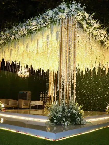 For a look of pure elegance, I designed this all-white mandap. The structure is draped in thousands of white floral strings, creating a serene and heavenly atmosphere, with the stage lighting adding a soft, warm glow from below.