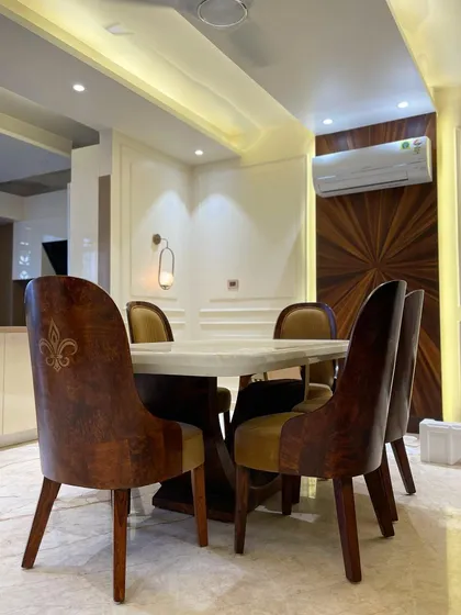 A beautiful dining space designed for making memories. The chairs feature custom embroidery, and the accent wall is clad in a sunburst veneer pattern, creating a warm and inviting atmosphere.
