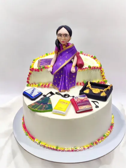 A custom cake to celebrate a 70th birthday, featuring a figurine of the woman and some of her favorite things, like her books and jewelry.