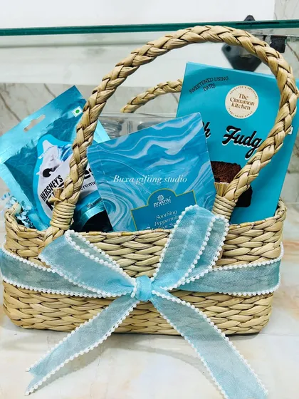 A thoughtful gift for a new mom after welcoming her baby boy. This pastel blue jute hamper is filled with skincare and comfort foods.