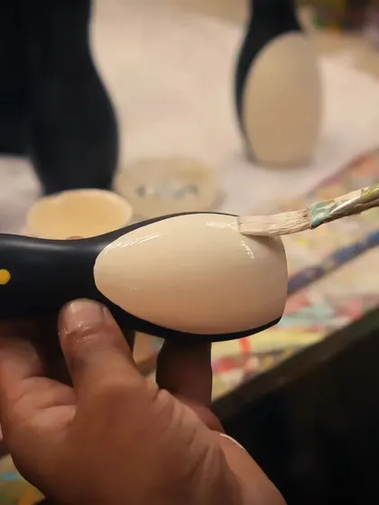 The final details are always painted by hand. This close-up shows an artisan carefully applying natural dye to a penguin toy, a testament to the skill and patience that goes into every single piece we create. This is what makes each Channapatna wooden toy unique.