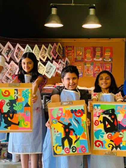 A group of students with their finished Henri Matisse-inspired collages, showcasing their understanding of shape and color.