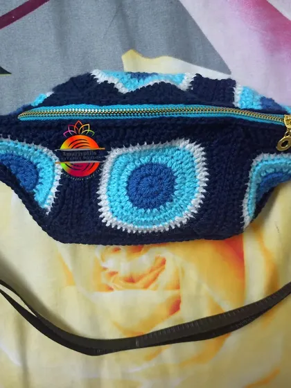 My Evil Eye themed travel pouch is a customer favorite. This crochet fanny pack is perfect for keeping your essentials safe while on the go, featuring a durable zipper and an adjustable strap for comfort.