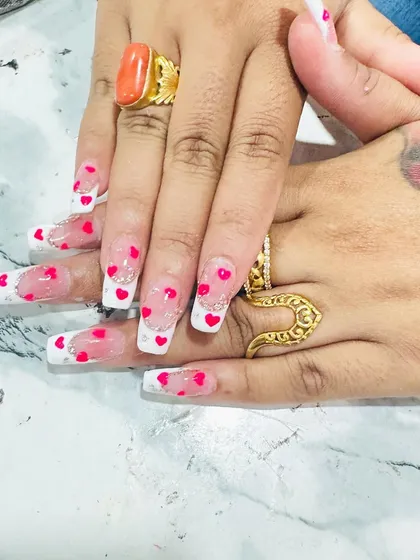 A playful and romantic design with encapsulated hearts. This clear nail set features a French tip, silver glitter, and tiny red hearts that appear to float inside the nail.