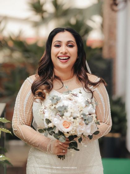 A joyful portrait of the bride holding her bouquet, her laugh capturing the happiness of the moment.