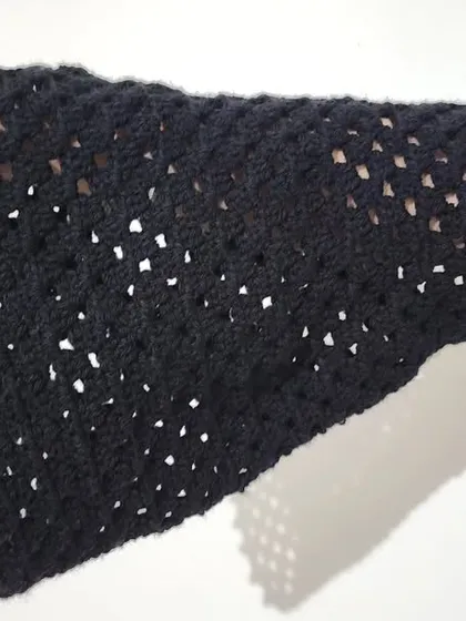 A close-up of the bell sleeve, showing the delicate mesh stitch and scalloped edge.