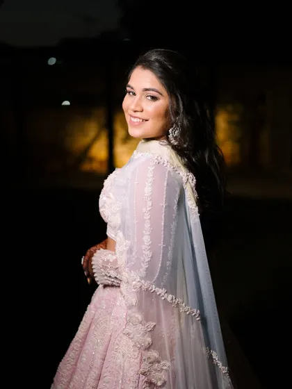 A beautiful night-time shot of the bride in her engagement gown. The soft lighting enhances her glowing makeup and the delicate details of her outfit.