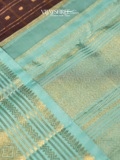 A close-up of the contrast between the checked black body and the shimmering blue and gold pallu.