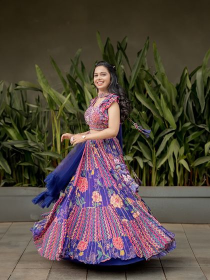 A joyful shot of the bride twirling in her vibrant, colorful lehenga. This photo is full of life, movement, and happiness, perfectly capturing her celebratory spirit.