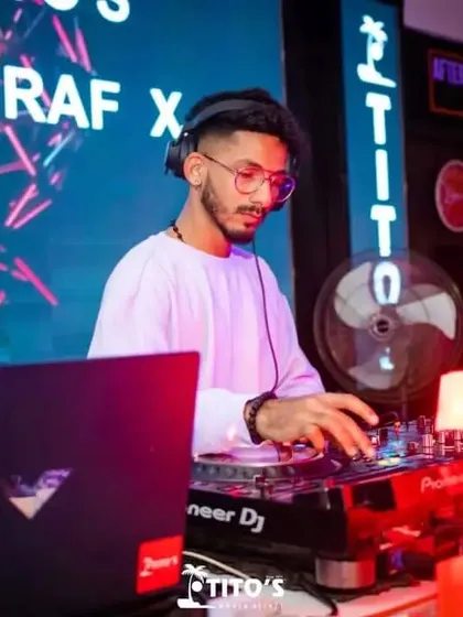 A focused moment at the DJ booth at Tito's. The purple and blue lighting creates a cool, modern vibe while I mix.