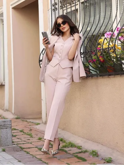 A complete look at the dusty pink three-piece power suit, showing how the blazer, waistcoat, and trousers come together for a perfectly coordinated and tailored outfit.