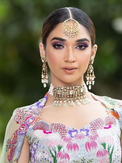 A close-up of the dreamy Mehendi look, focusing on the beautiful eye makeup and the intricate maang tikka.