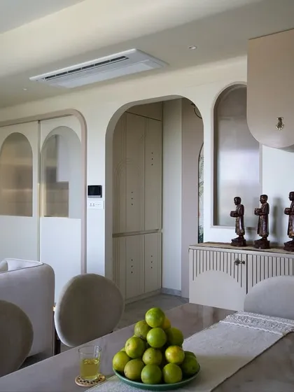 The dining area in the 'Vrindavan' project, featuring curved overhead cabinets and elegant arches. This space is designed for family gatherings, blending seamlessly with the open-plan living room.