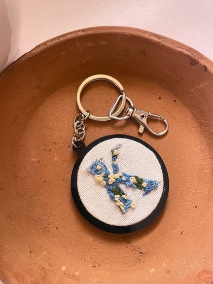 Another shot of the floral 'K' initial keychain, showing the delicate stitch work from a different angle.