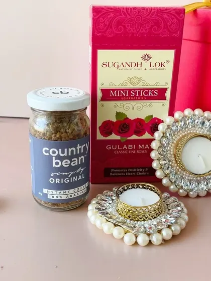 A close-up of some of the items in the round box hamper, including Country Bean coffee and ornate pearl T-light holders. I focus on quality products in every hamper.