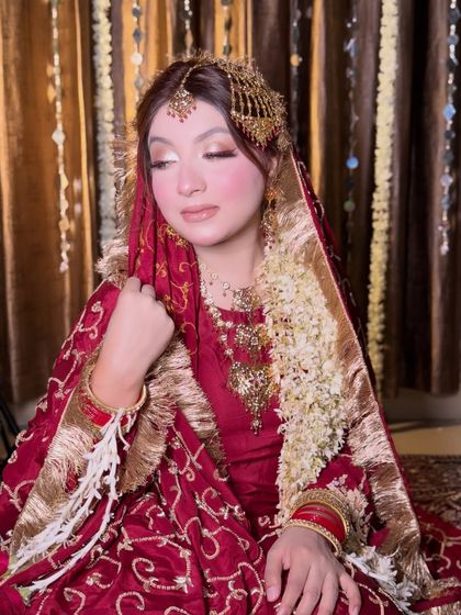 A beautiful, soft-focus portrait of the bride. Her makeup is classic and timeless, perfect for the vintage feel of her outfit.